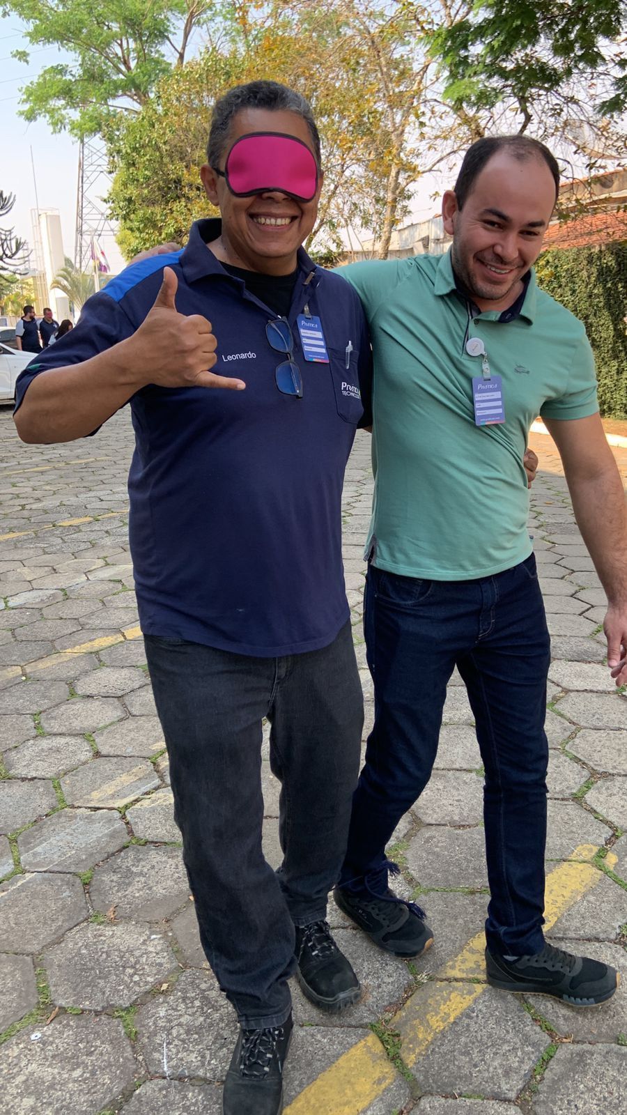 Dois homens estão parados um ao lado do outro na calçada. um dos homens está usando uma venda.