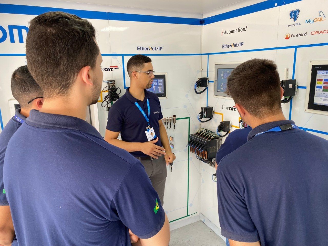 Um homem está conversando com um grupo de jovens em uma sala.