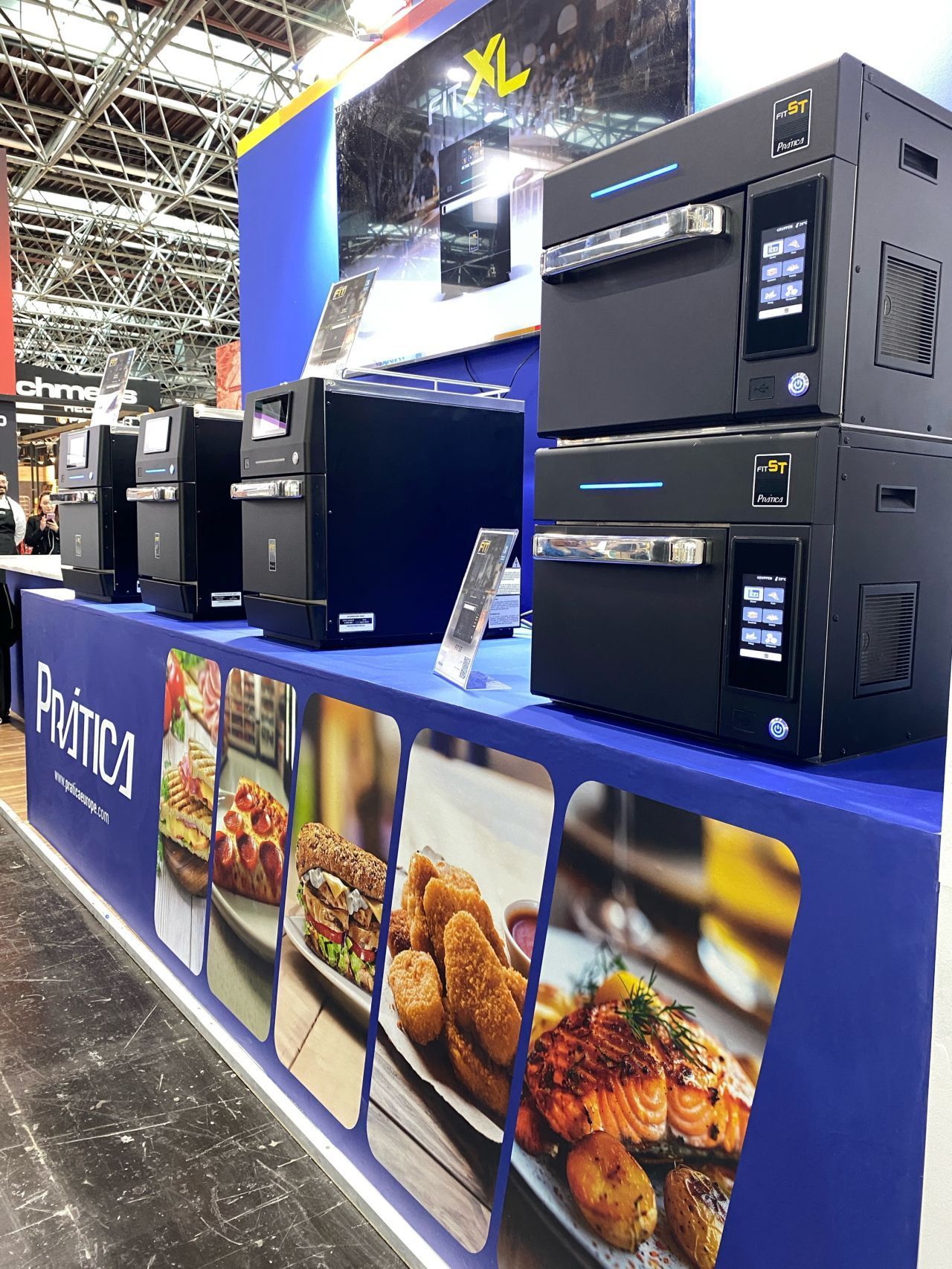 Uma fileira de micro-ondas empilhados uns sobre os outros sobre uma mesa.