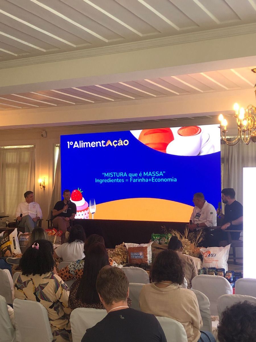 Um grupo de pessoas está sentado em frente a uma tela grande.