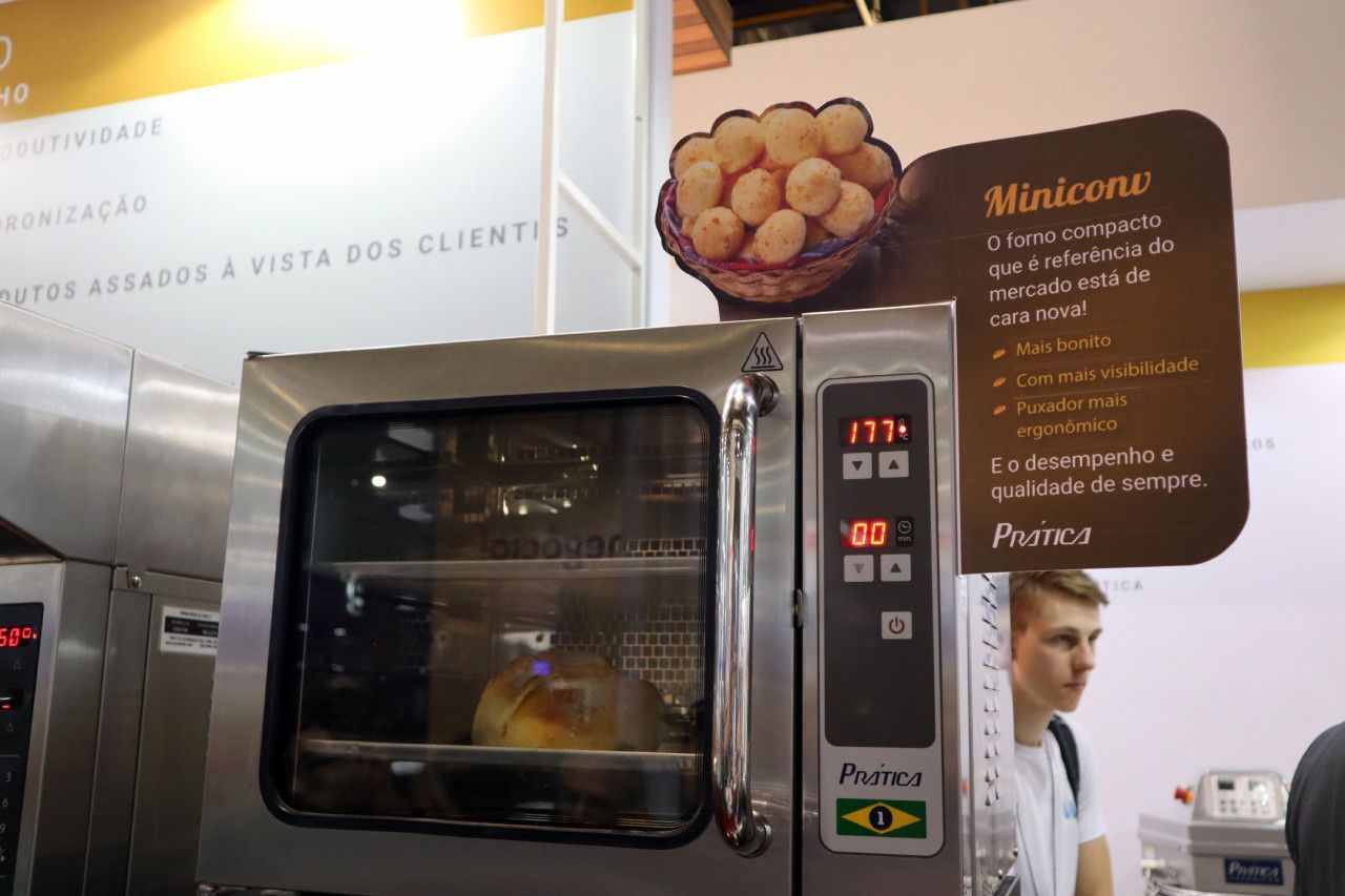 Um homem está em frente a um forno miniconv