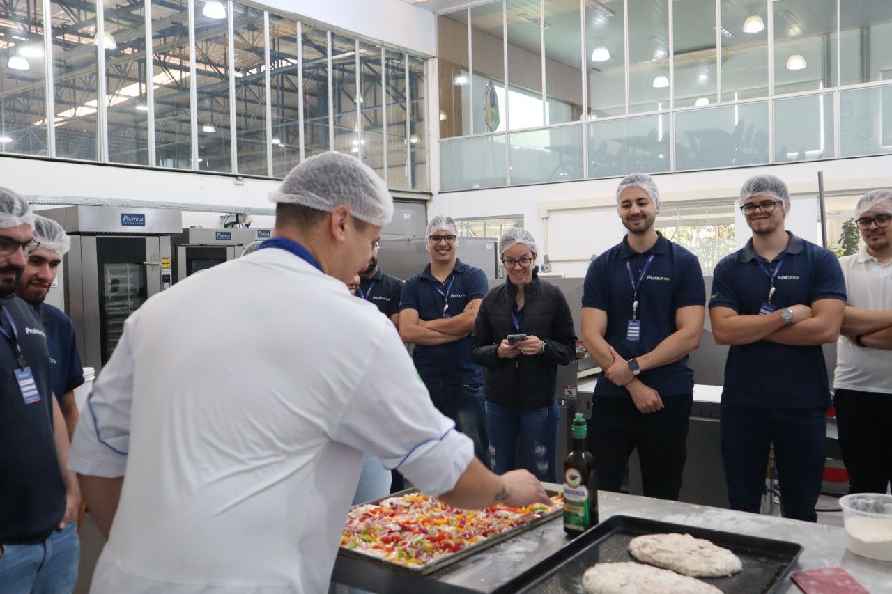 Um grupo de homens está em volta de uma bandeja de pizza.