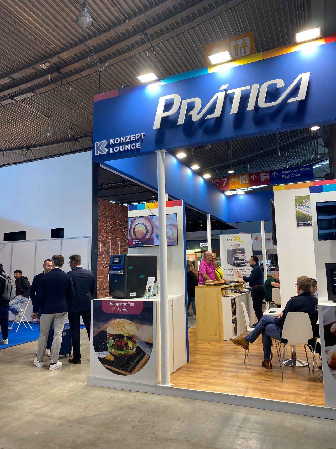 Um grupo de pessoas está em volta de um estande que diz pratica