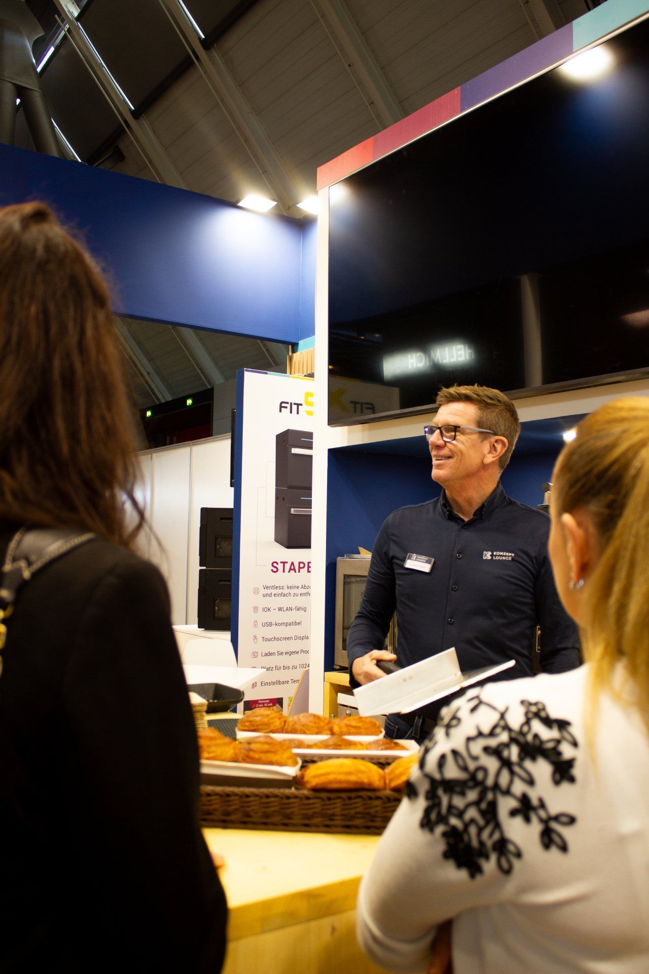 Um homem está conversando com um grupo de pessoas em uma sala.