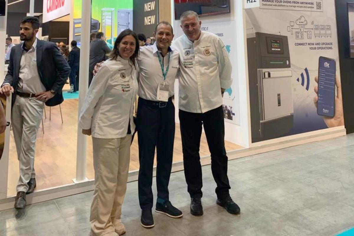 Um grupo de pessoas está posando para uma foto em uma convenção.