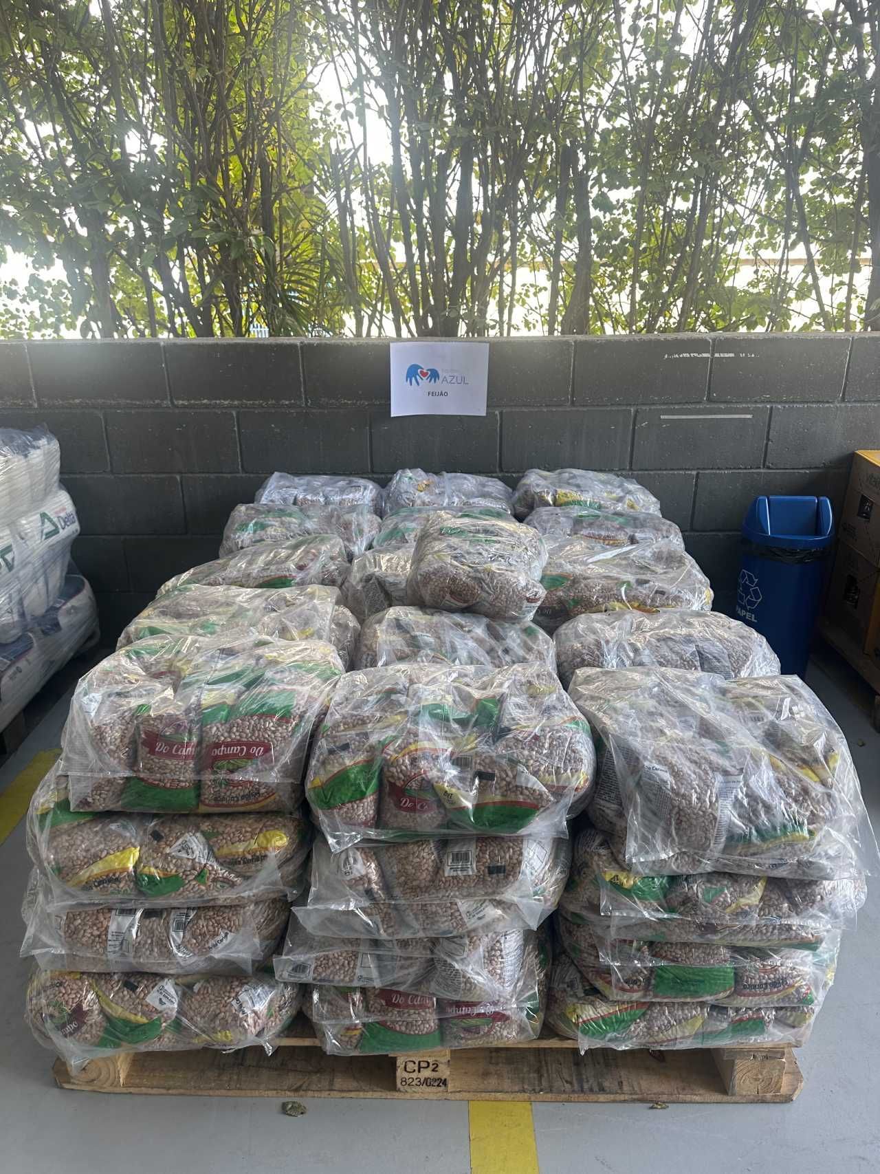 Um palete de madeira cheio de sacos de comida em um armazém.