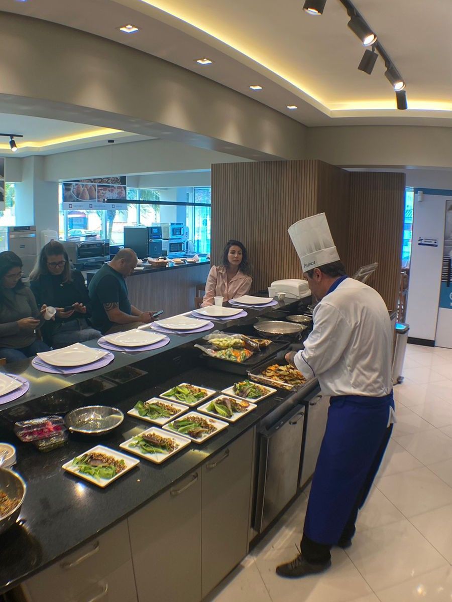 Um chef está preparando comida em uma mesa de bufê em um restaurante