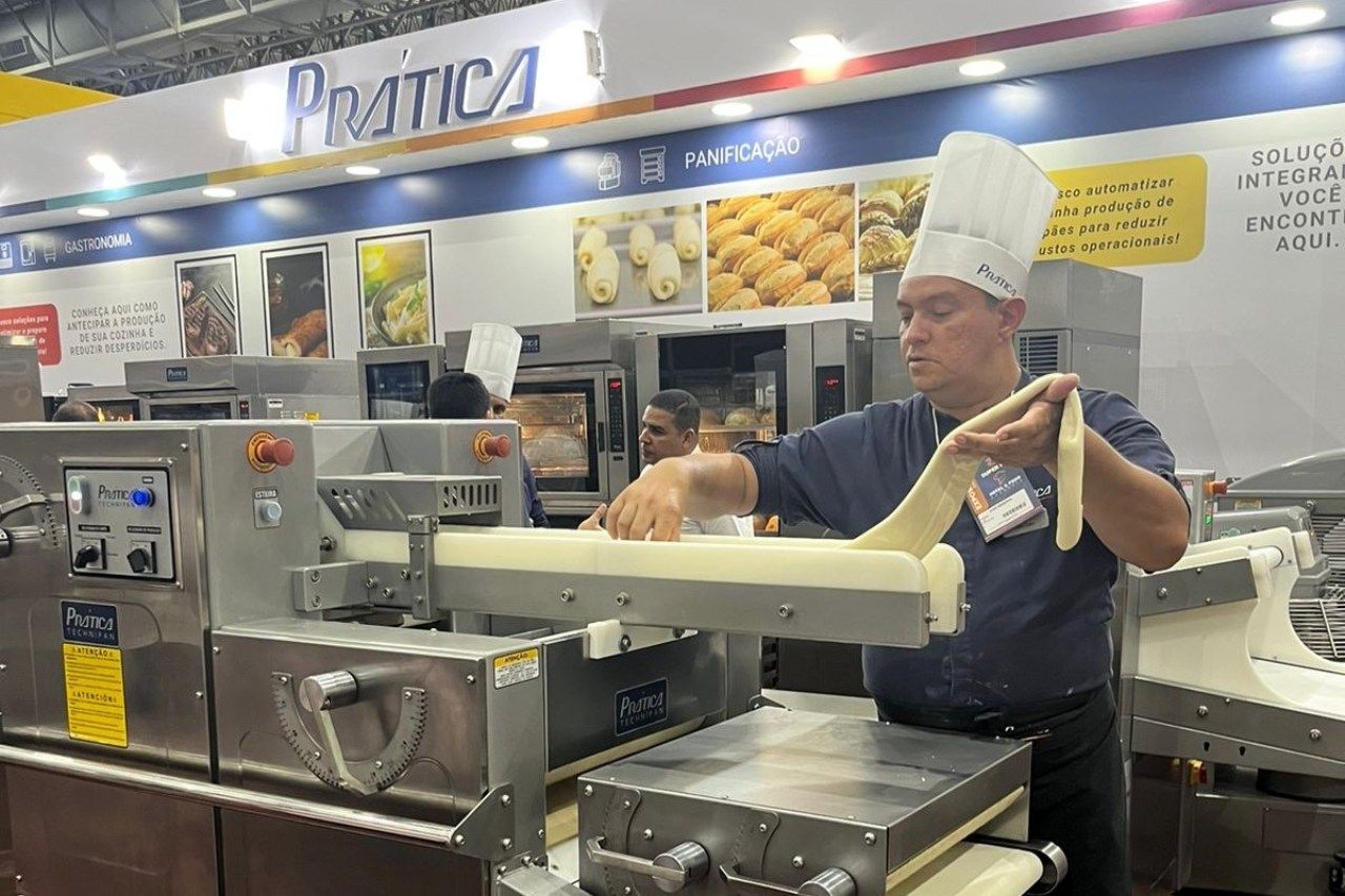 Um homem está trabalhando em uma máquina na cozinha.