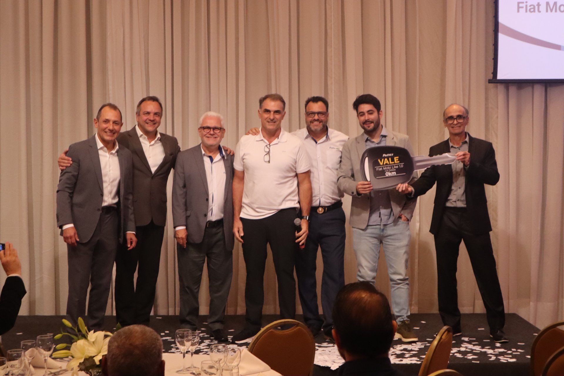 Um grupo de homens está posando para uma foto em um palco.