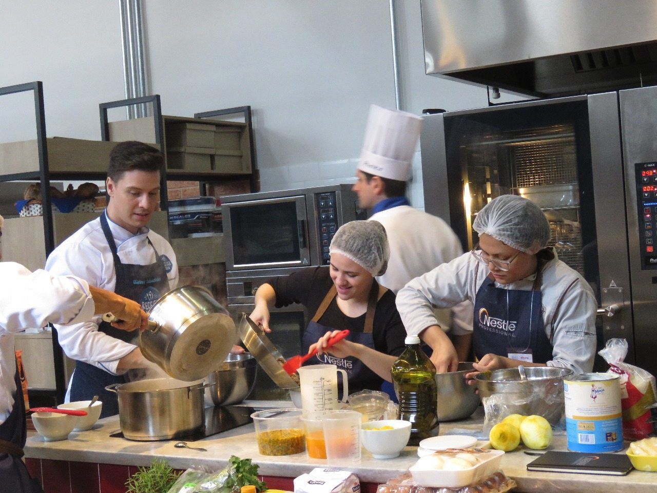 Um grupo de chefs está preparando comida em uma cozinha