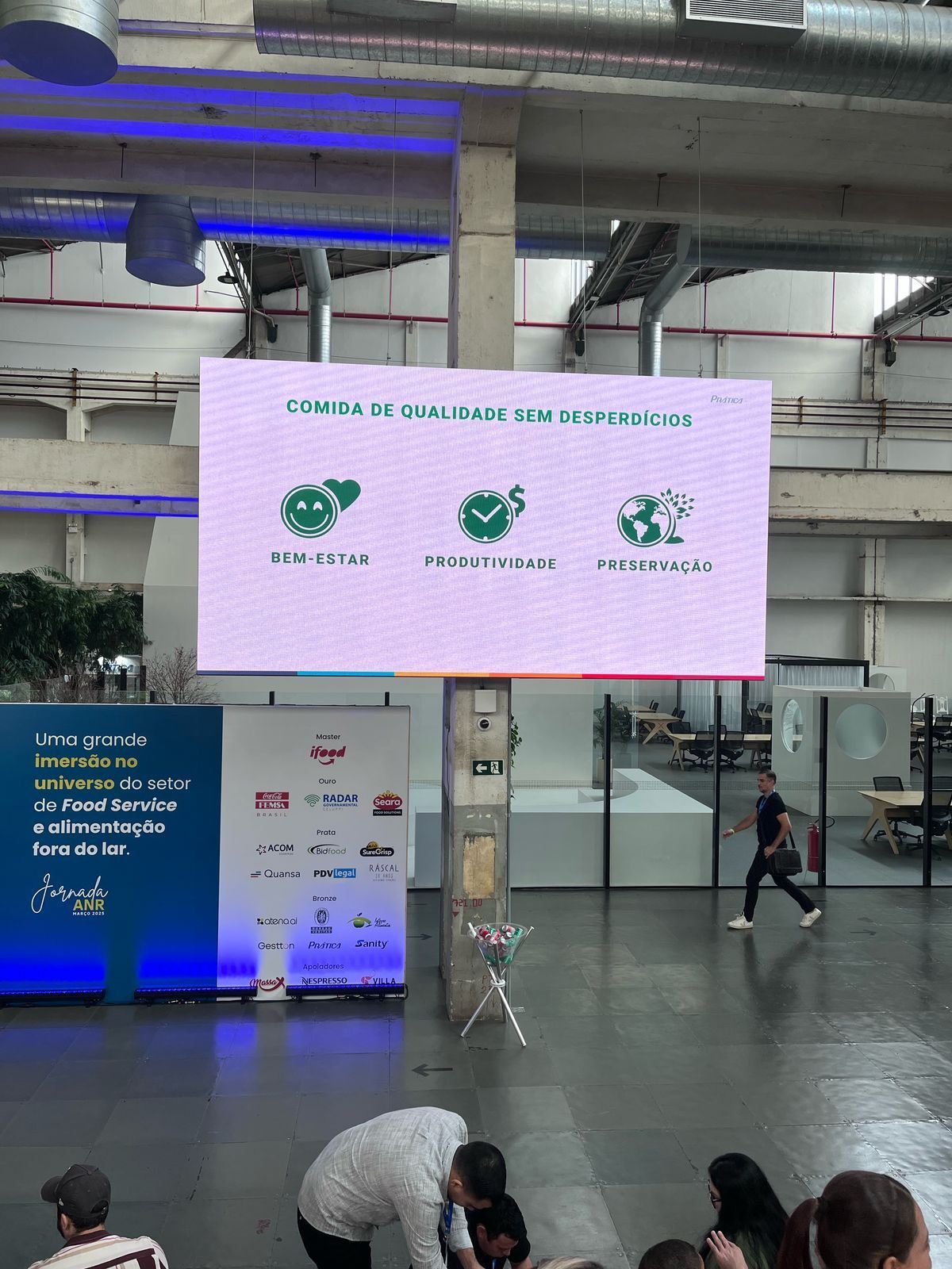 Um grupo de pessoas está sentado em frente a uma tela grande.