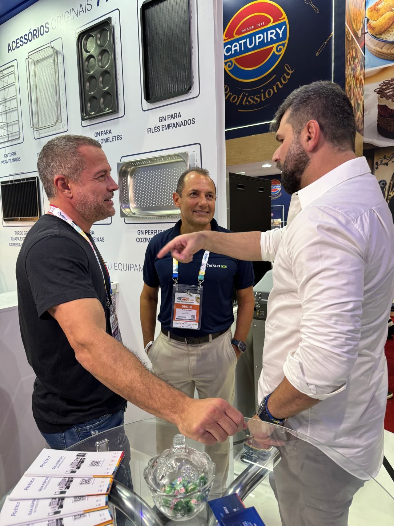 Um grupo de homens está em volta de uma mesa conversando entre si.