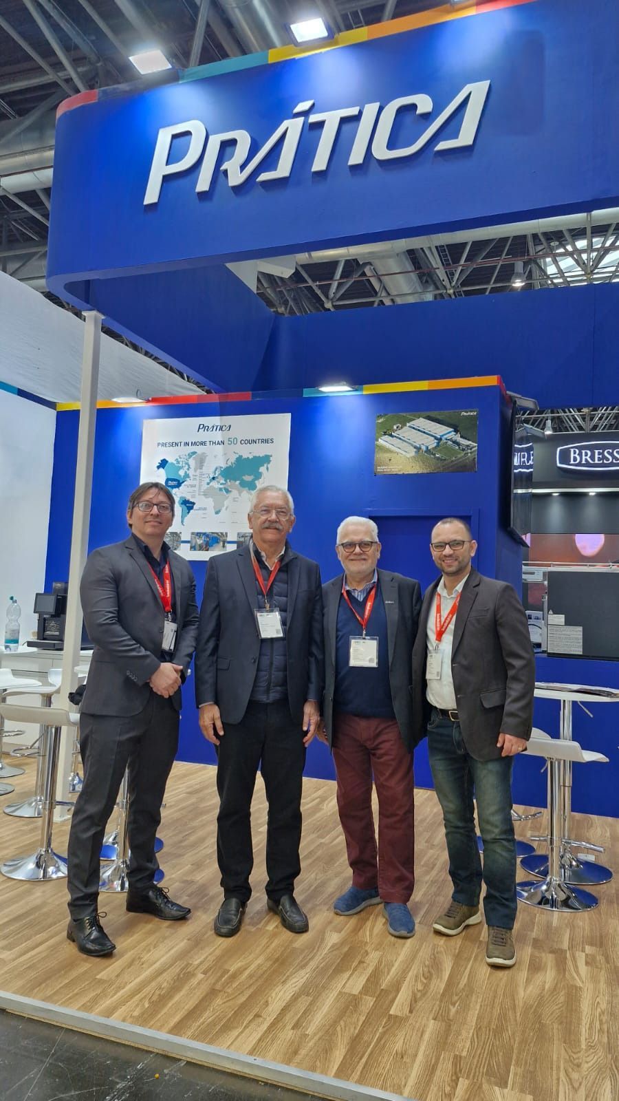 Um grupo de homens está em frente a um estande em uma convenção.