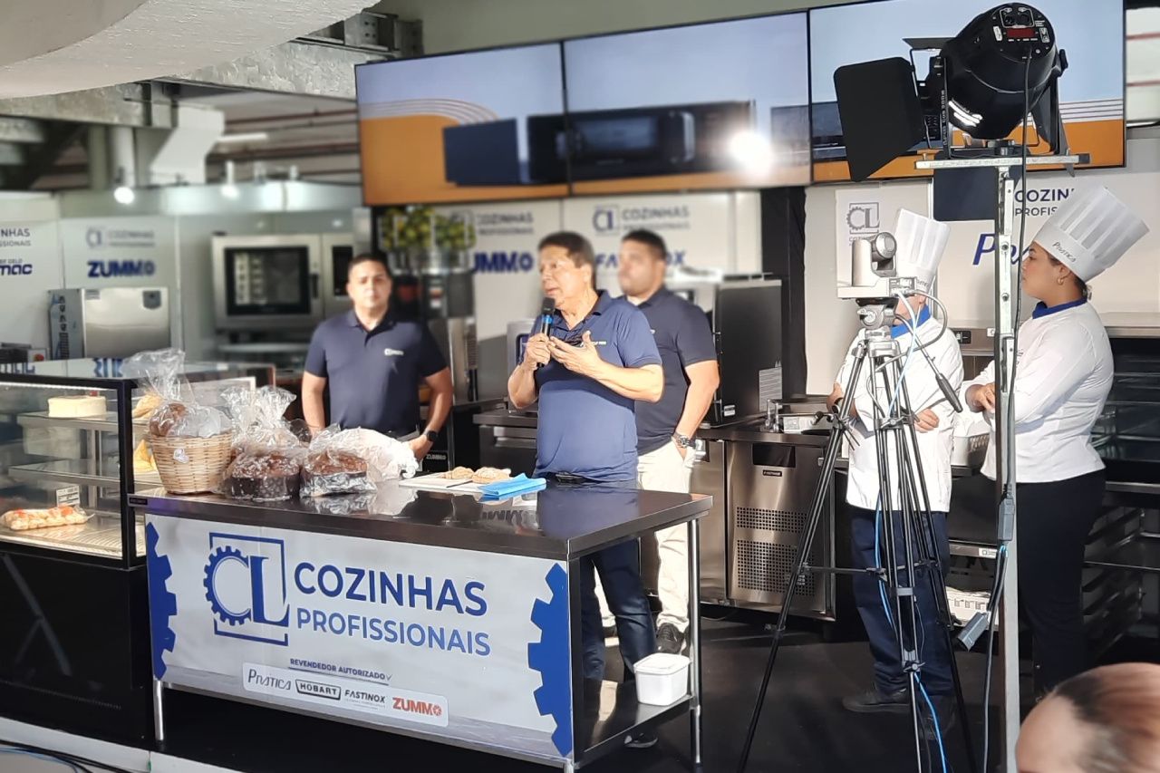 Um grupo de pessoas em pé ao redor de uma mesa com uma placa que diz cozinhas profissionais