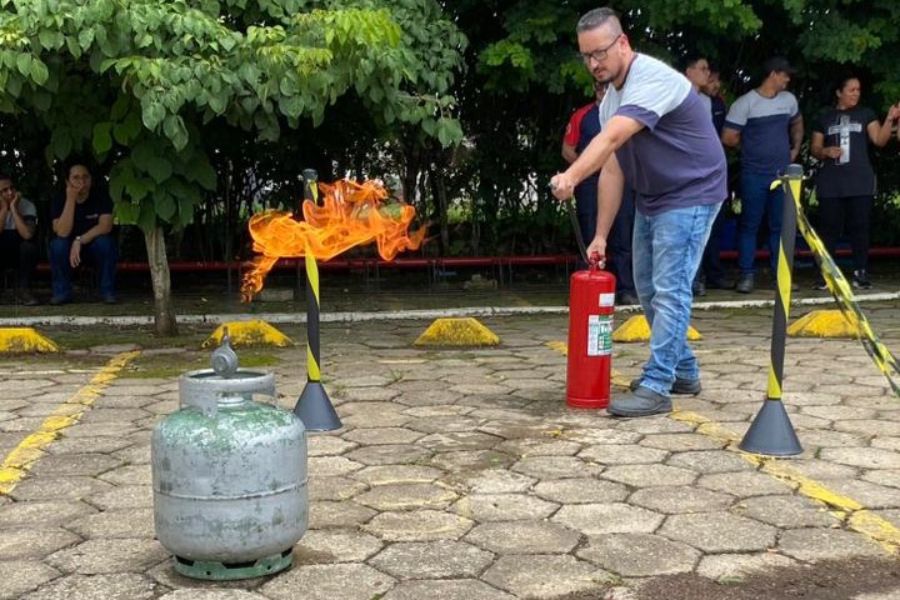 Um homem está usando um extintor de incêndio para apagar um incêndio.