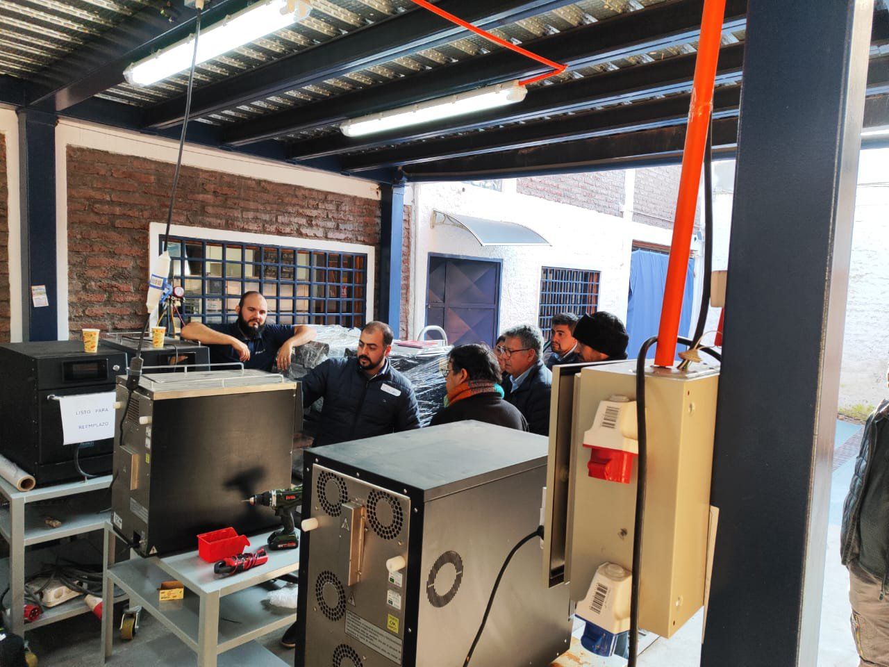 Um grupo de homens está em pé ao redor de uma máquina em uma sala.