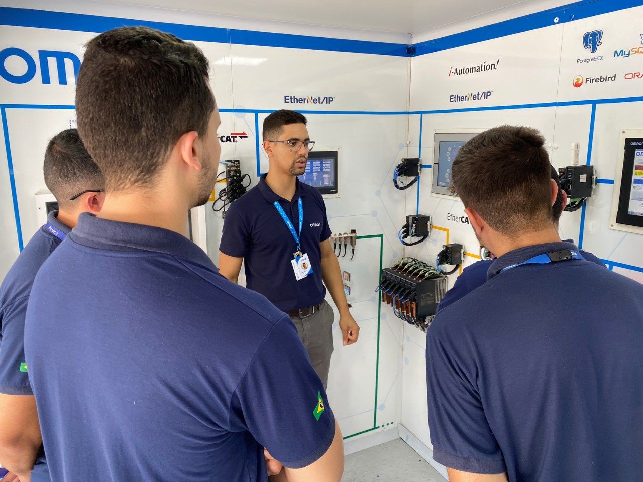Um homem está conversando com um grupo de jovens em uma sala.