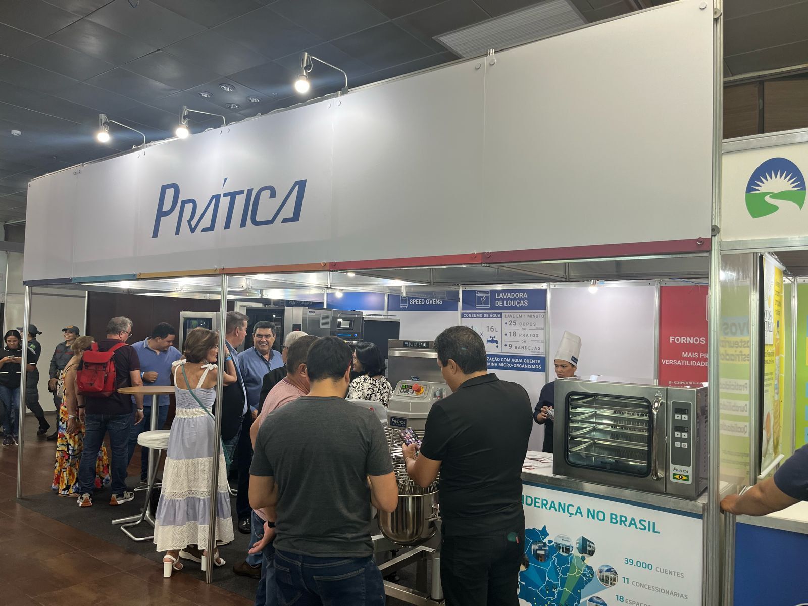 Um grupo de pessoas está em volta de um estande em uma convenção.