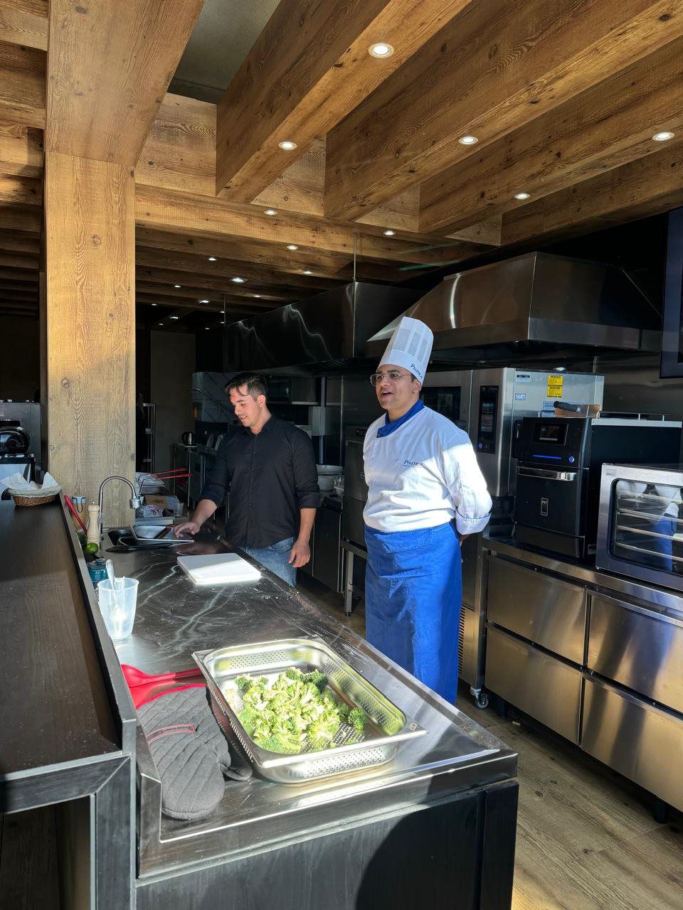 Dois chefs estão em uma cozinha preparando comida.