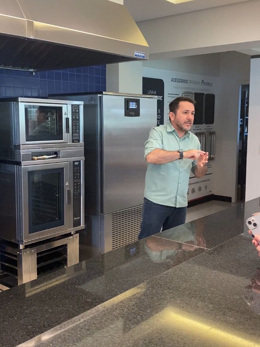 Um homem de camisa verde está parado na cozinha