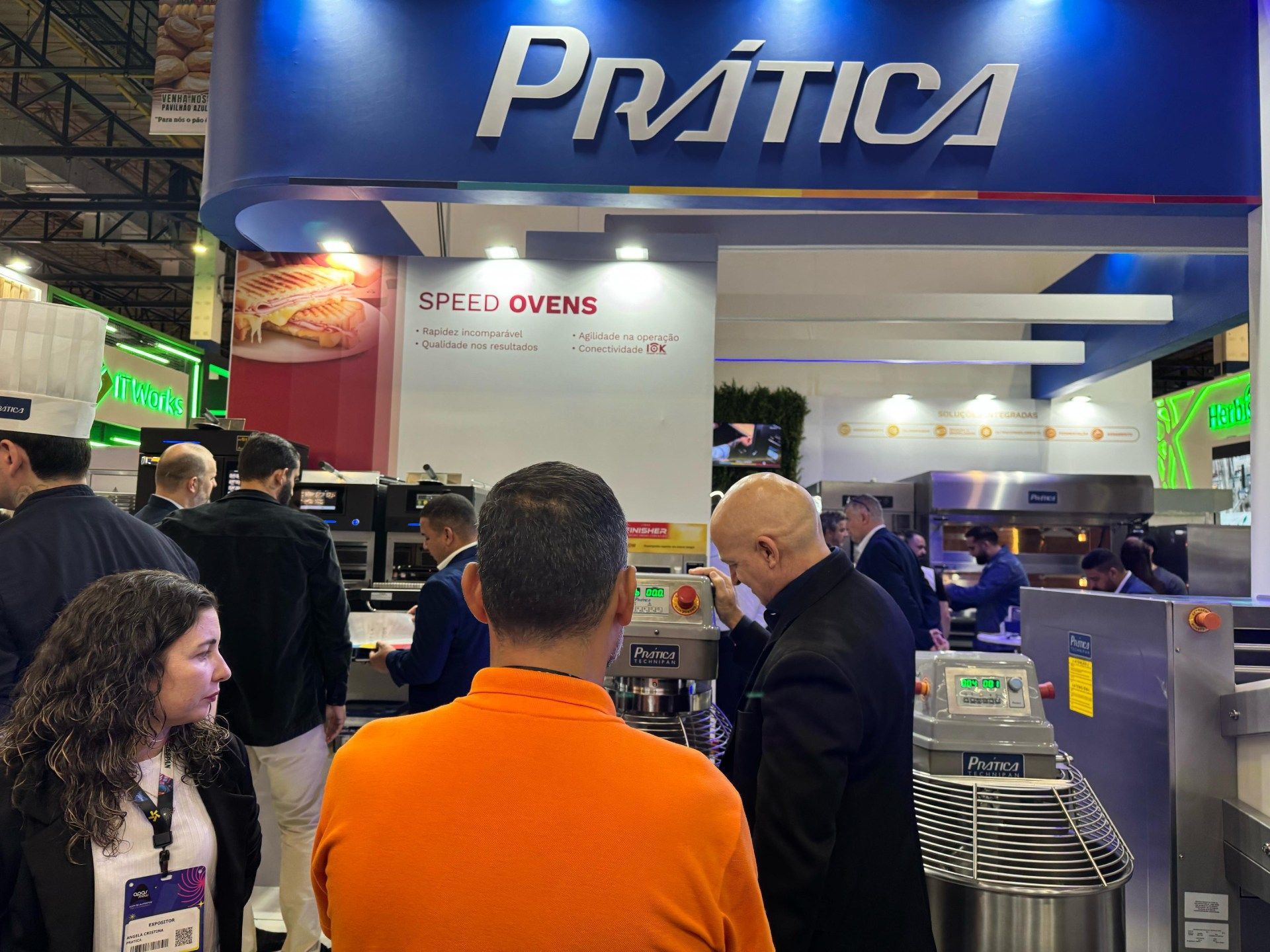 Um grupo de pessoas está parado sob uma placa que diz prática