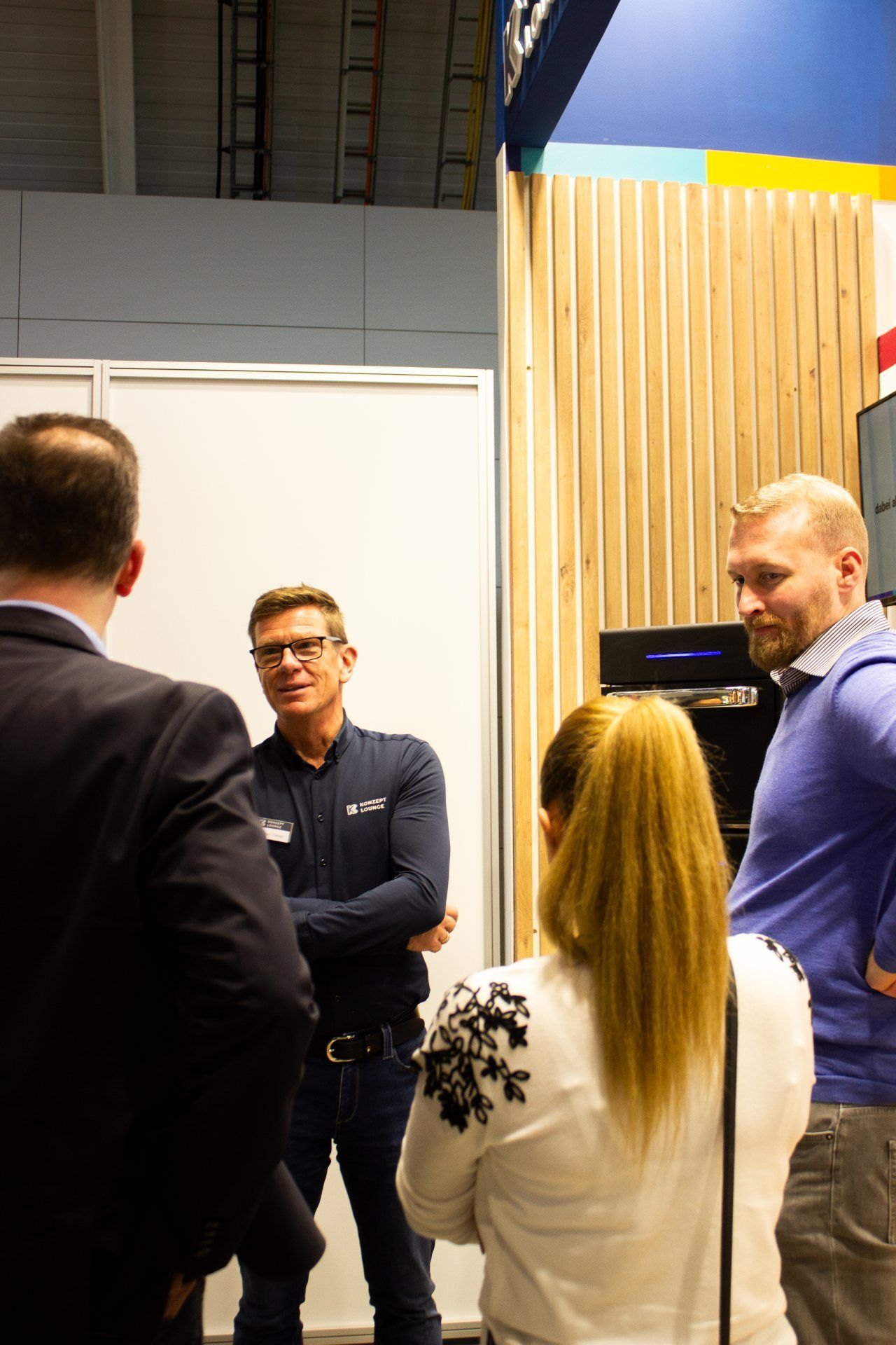 Um grupo de pessoas está em uma sala conversando entre si.