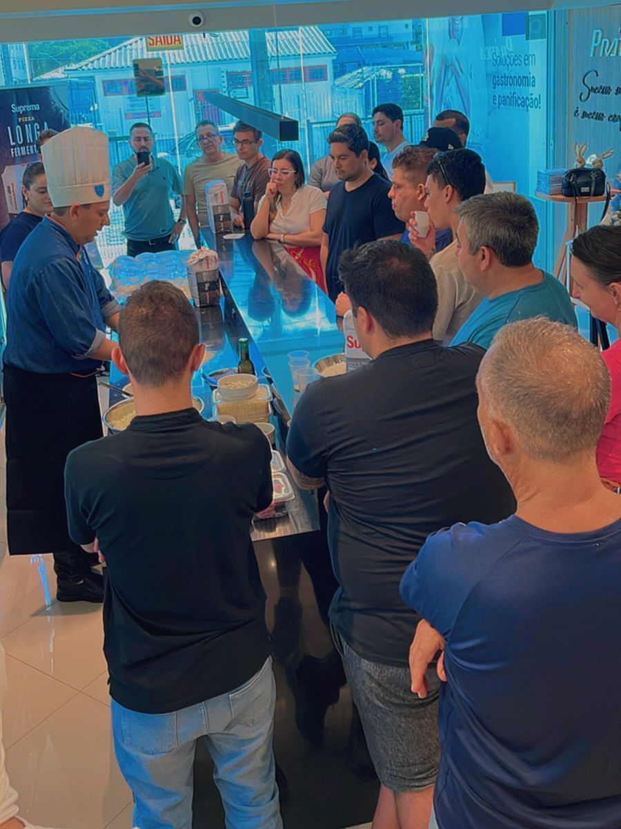 Um grupo de pessoas está em volta de um balcão em um restaurante.