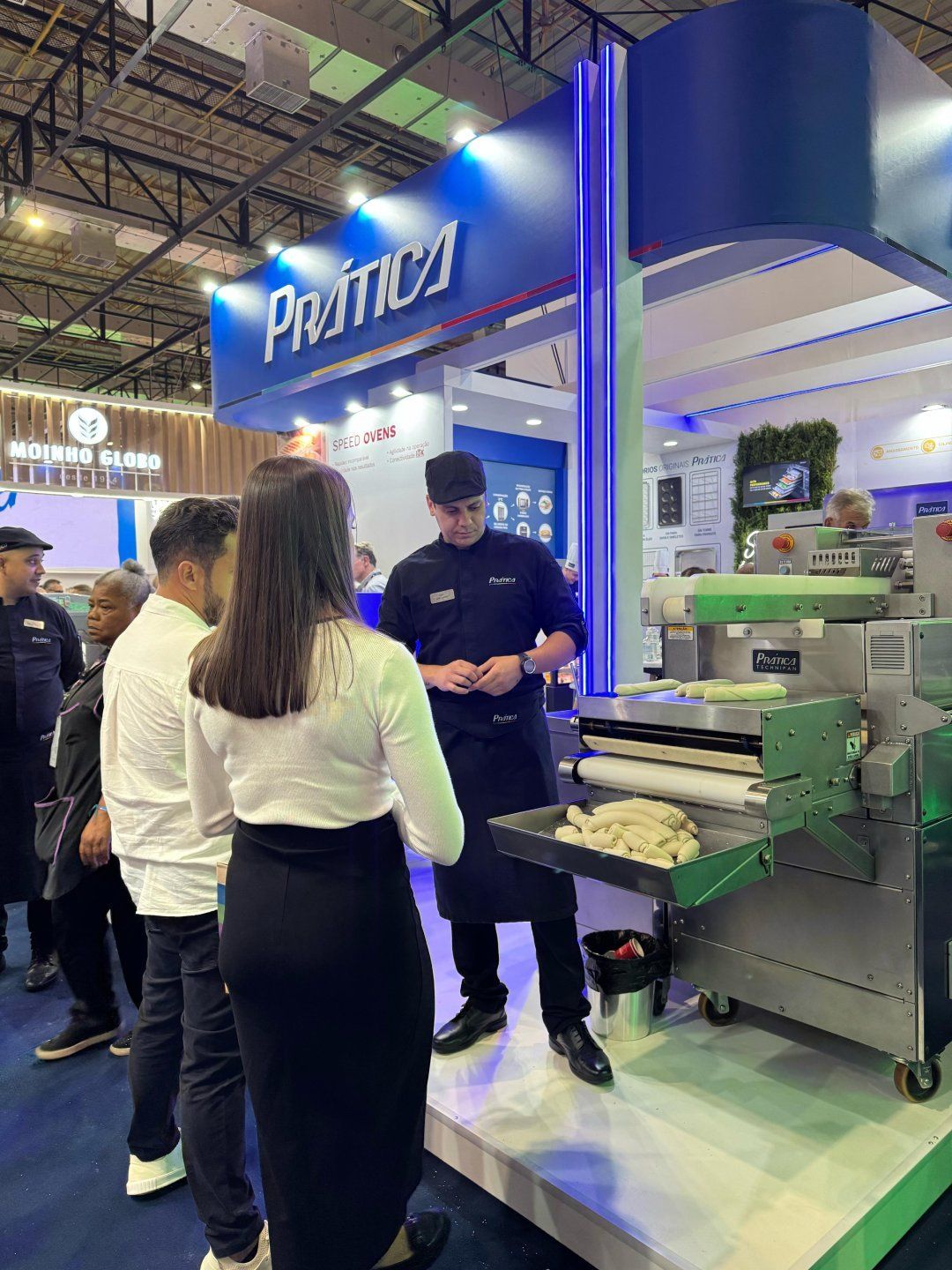 Um grupo de pessoas está em volta de uma máquina em uma convenção.