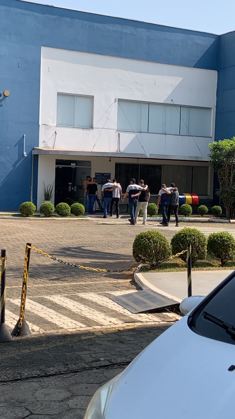 Um grupo de pessoas está do lado de fora de um prédio.