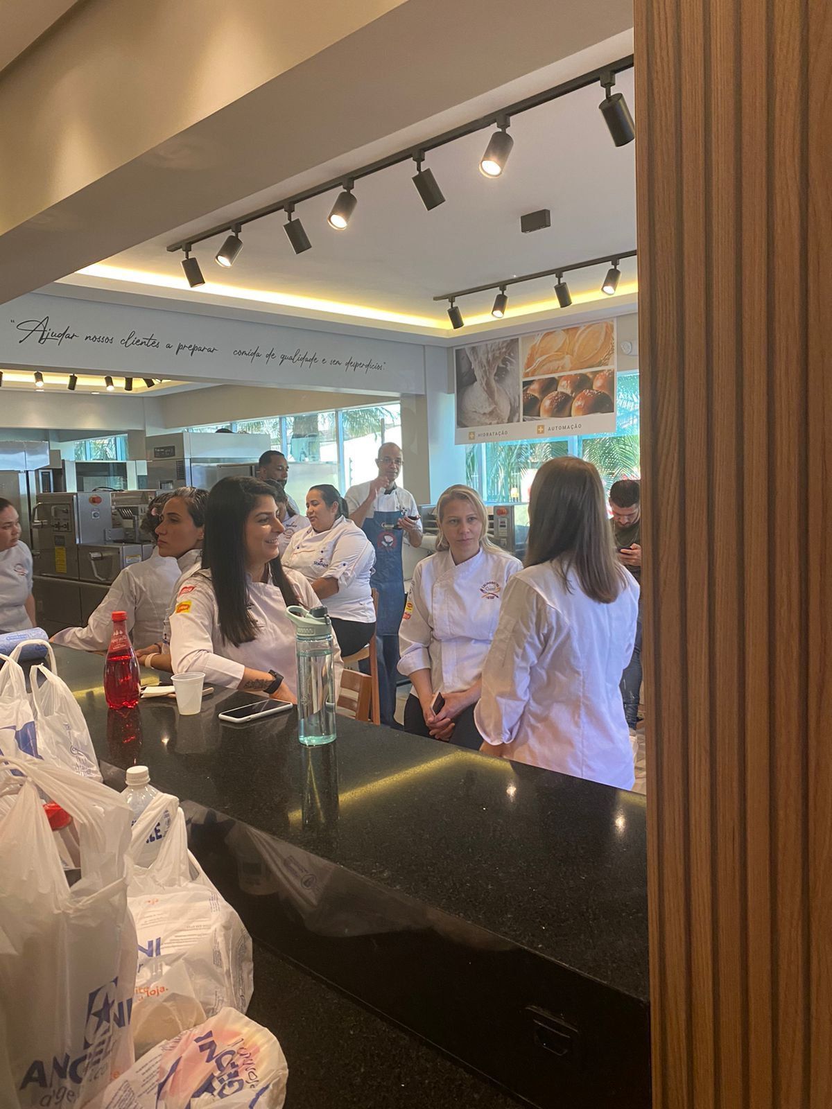 Um grupo de pessoas está sentado no balcão de um restaurante.