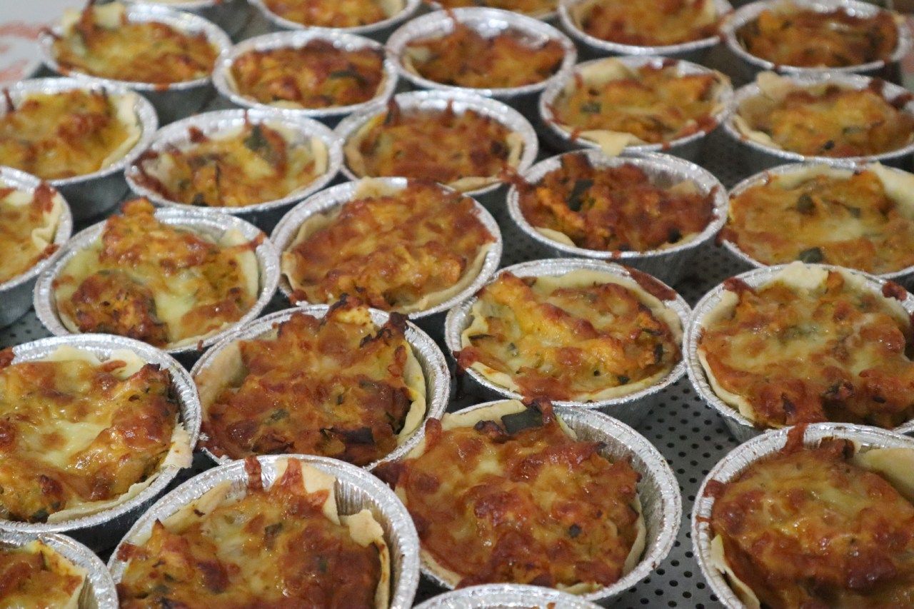 Um monte de cupcakes estão sobre uma mesa.