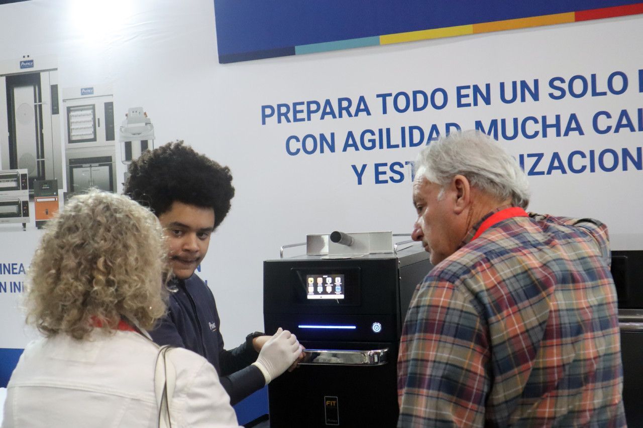 Um homem e uma mulher estão olhando para uma máquina.