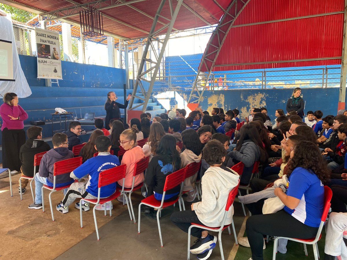 Um grupo de pessoas está sentado em cadeiras sob uma tenda.