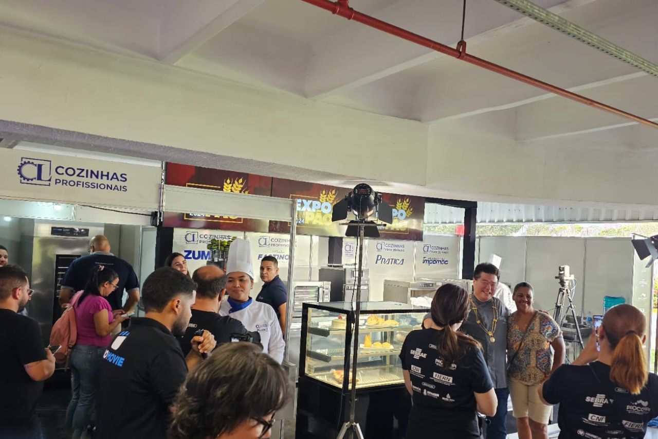 Um grupo de pessoas está em volta de uma vitrine em um restaurante.