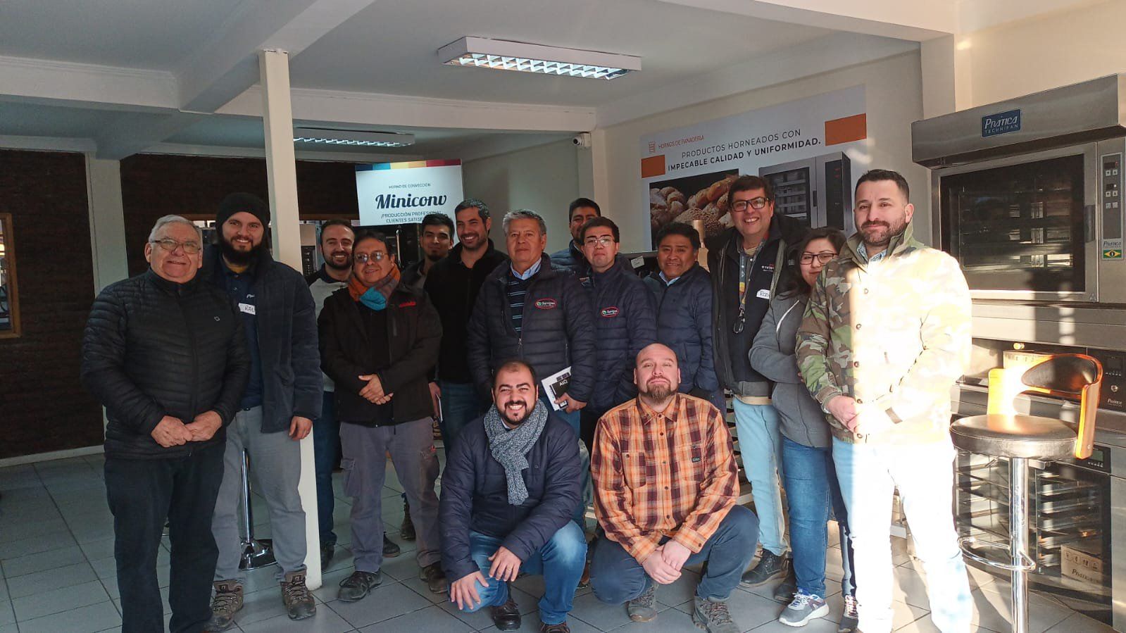 Um grupo de homens está posando para uma foto em uma sala.