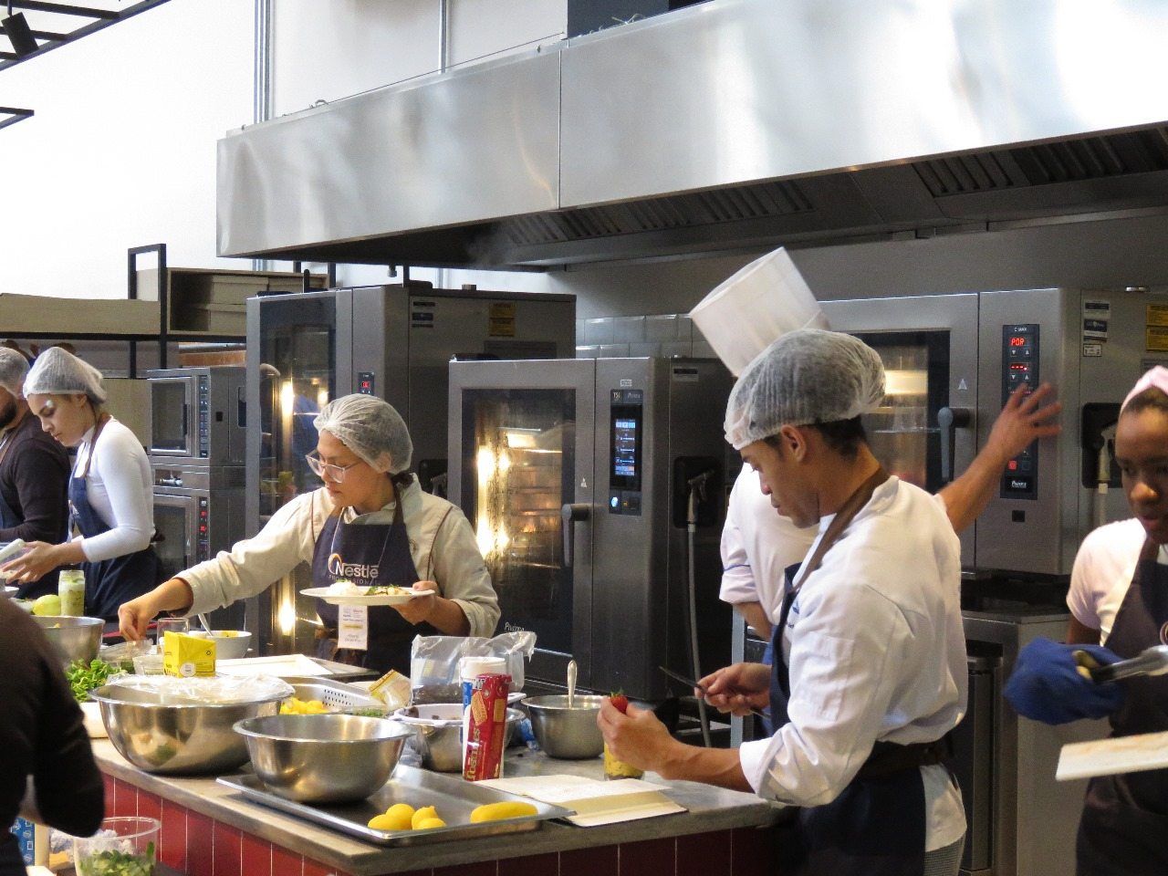 Um grupo de chefs está preparando comida em uma cozinha