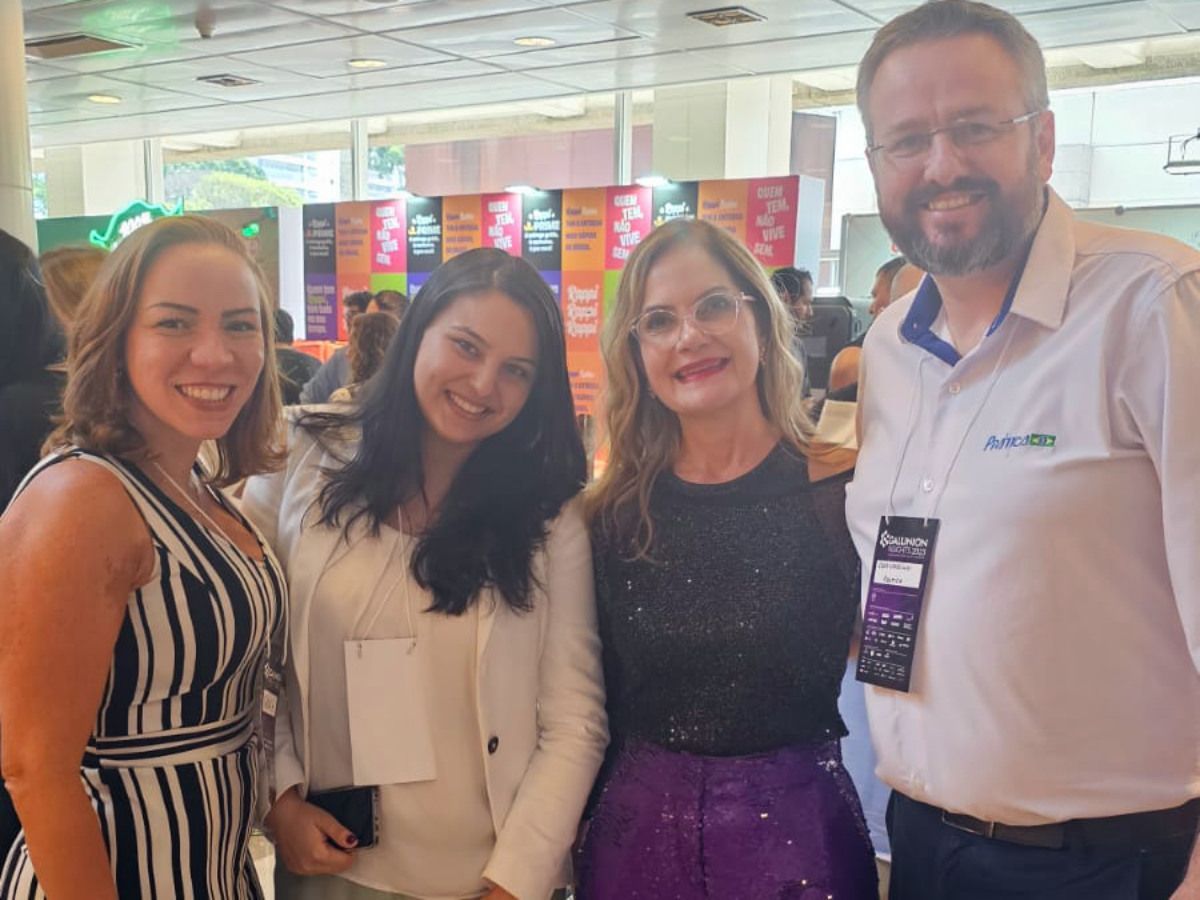 Um grupo de pessoas está posando para uma foto em uma sala.