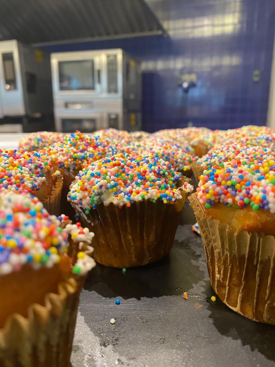 Um monte de cupcakes com granulado por cima