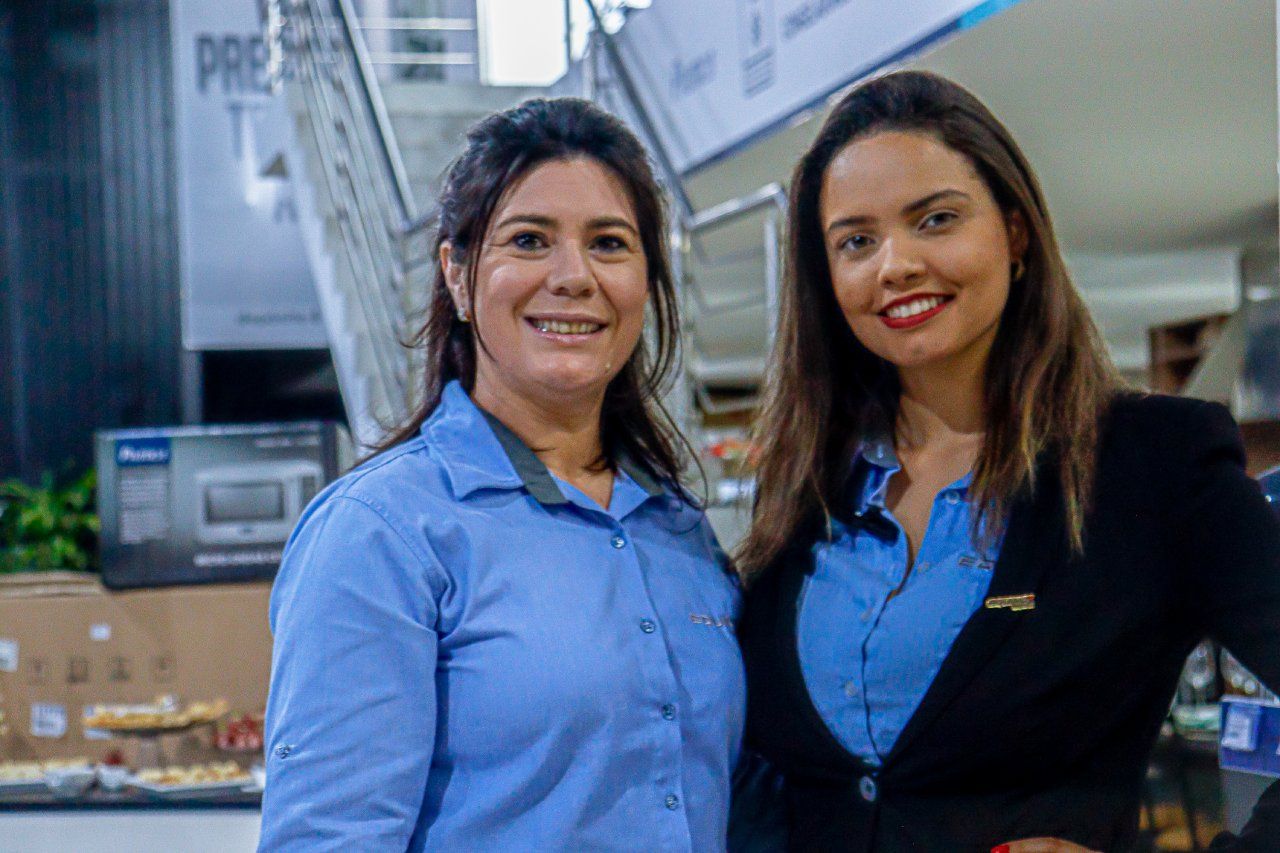 Duas mulheres estão posando para uma foto juntas em um restaurante.