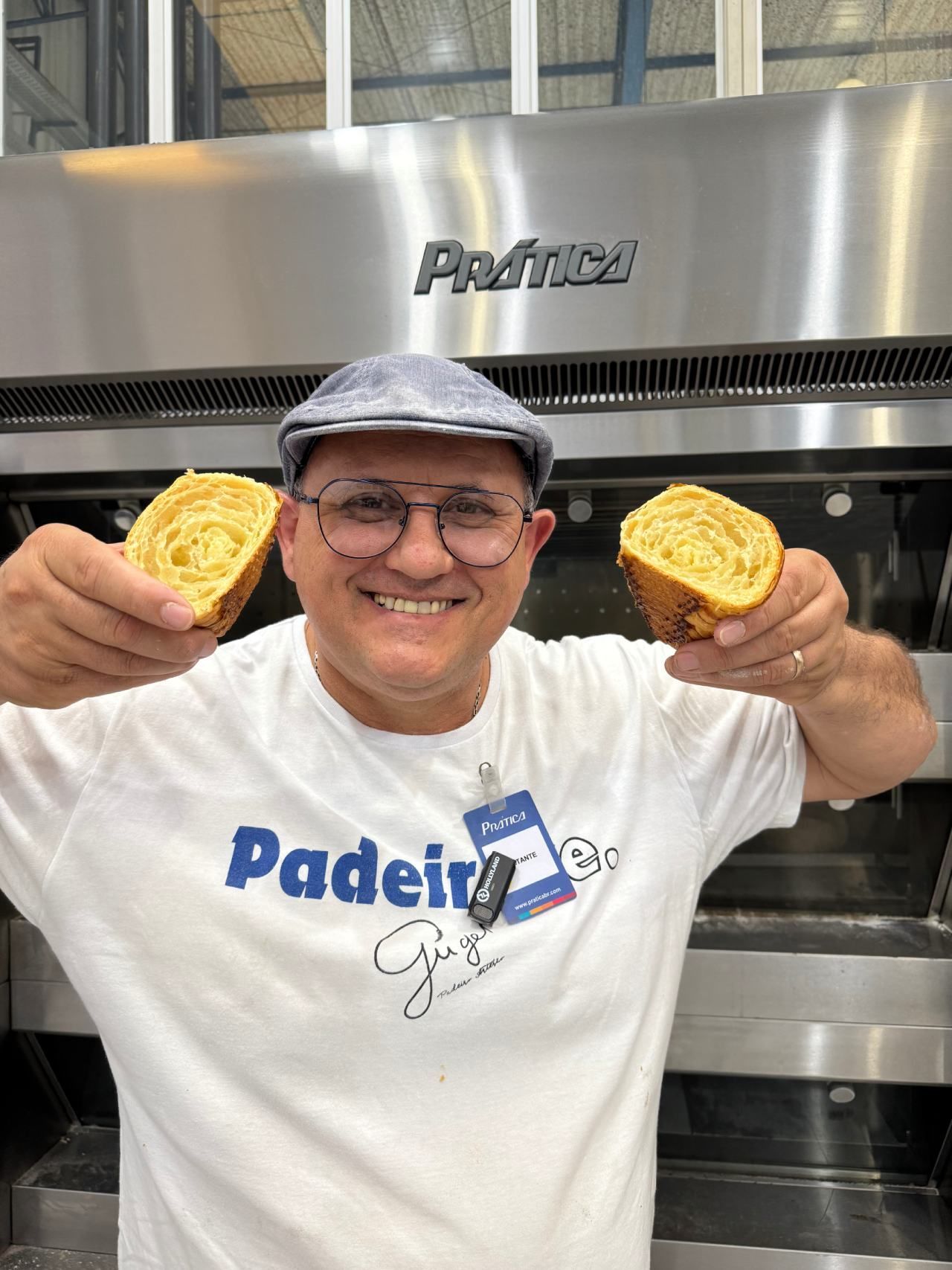 Um homem segura duas fatias de pão em frente ao forno.