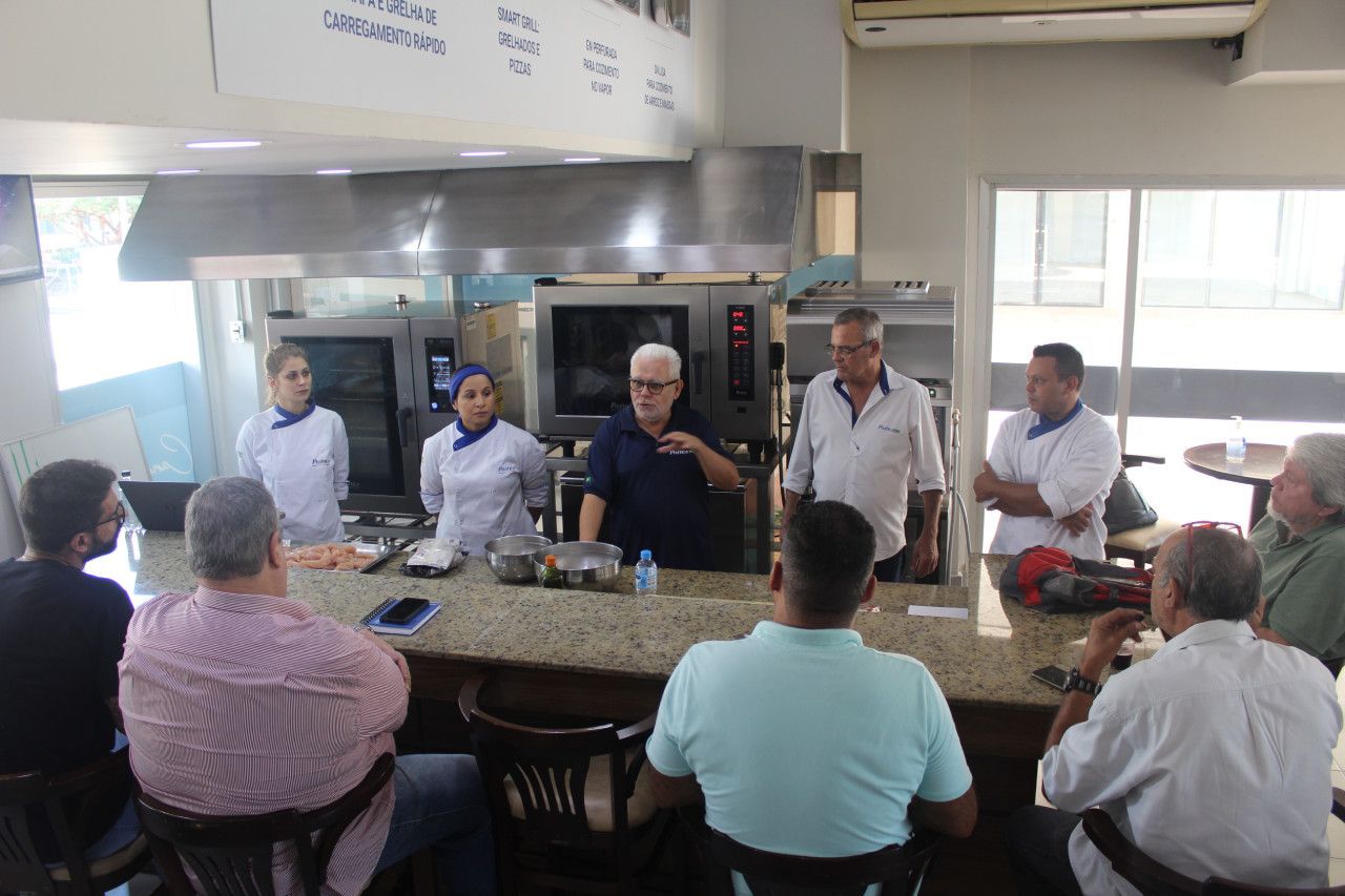 Um grupo de pessoas está sentado ao redor de uma mesa na cozinha.