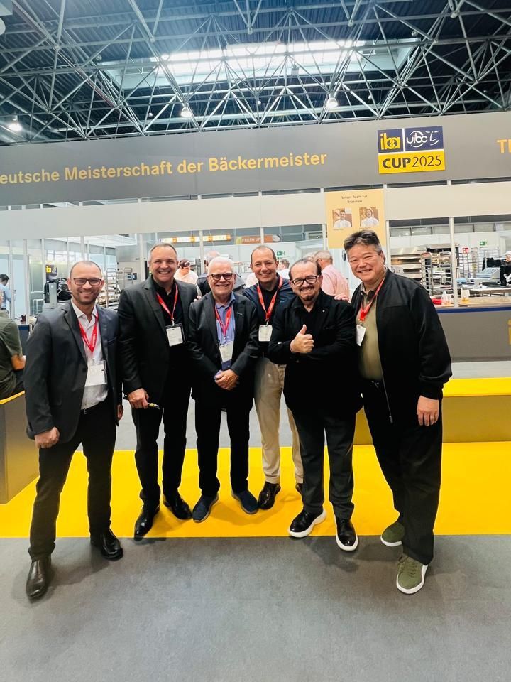 Um grupo de homens está posando para uma foto em uma convenção.