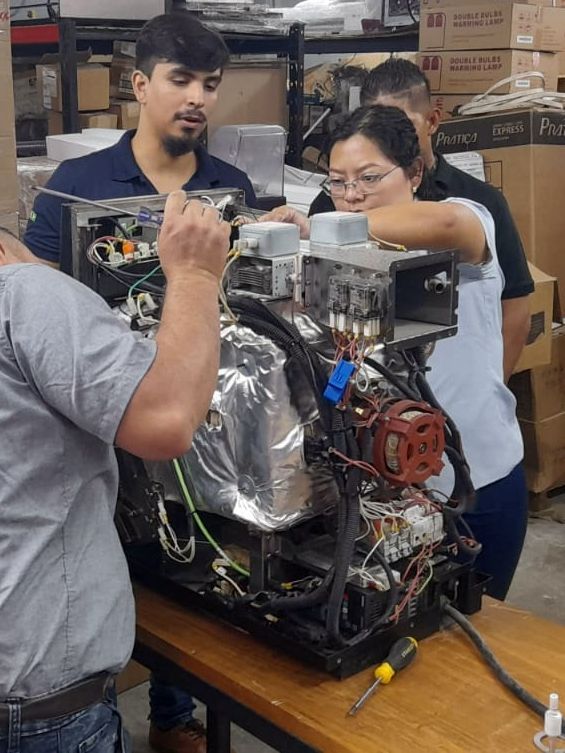 Um grupo de pessoas está trabalhando em uma máquina.