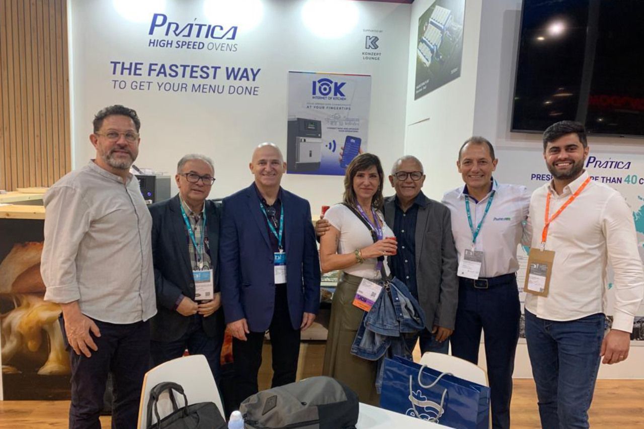 Um grupo de pessoas está posando para uma foto em uma convenção.