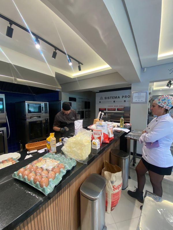 Um homem e uma mulher estão de pé em um balcão de uma cozinha.
