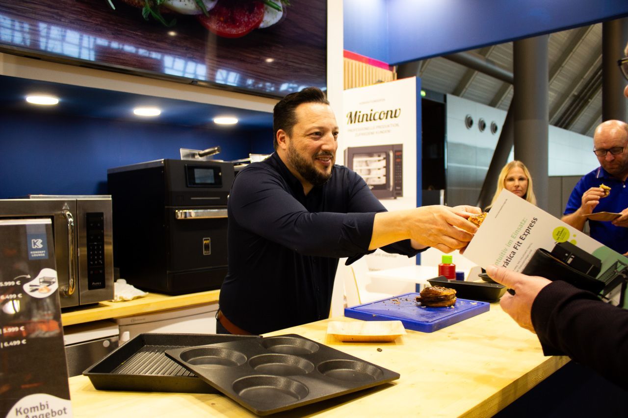 Um homem está apertando a mão de outro homem em uma mesa.