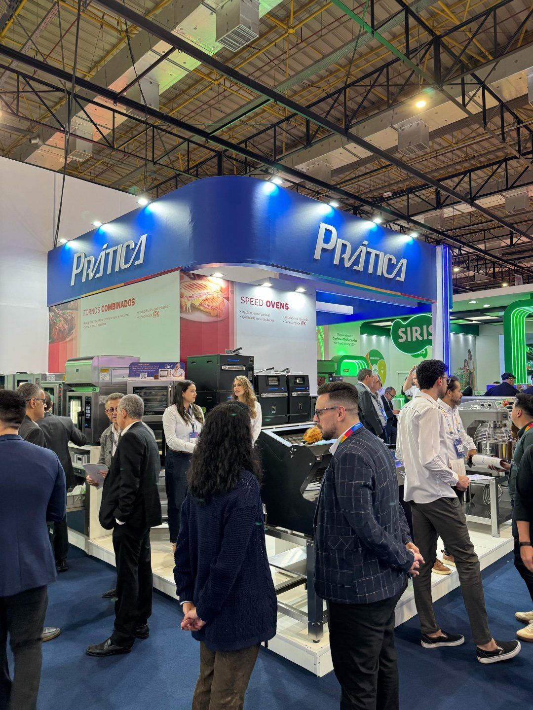 Um grupo de pessoas está em volta de um estande em uma convenção.