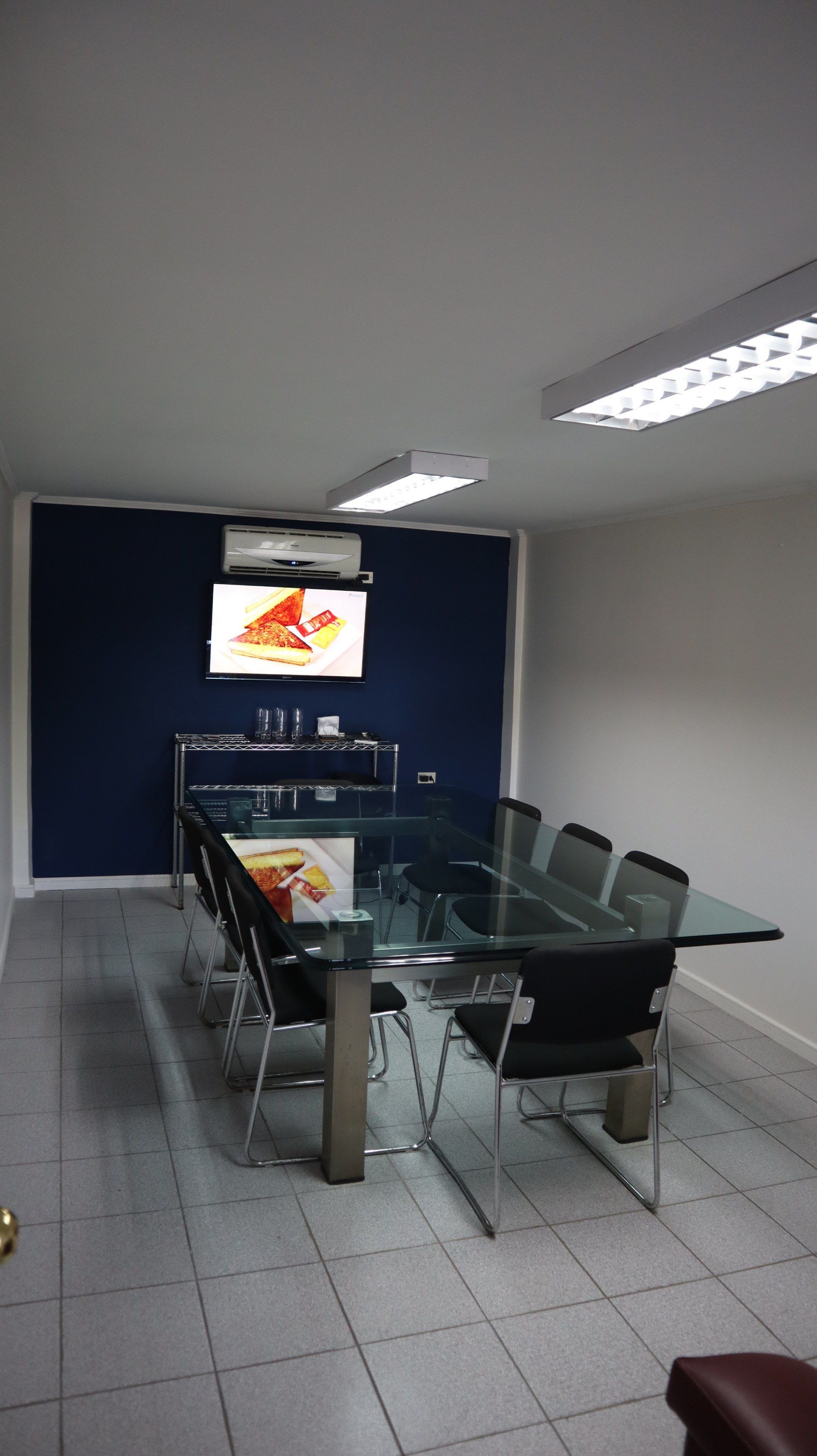 Uma sala de conferências com uma mesa e cadeiras de vidro