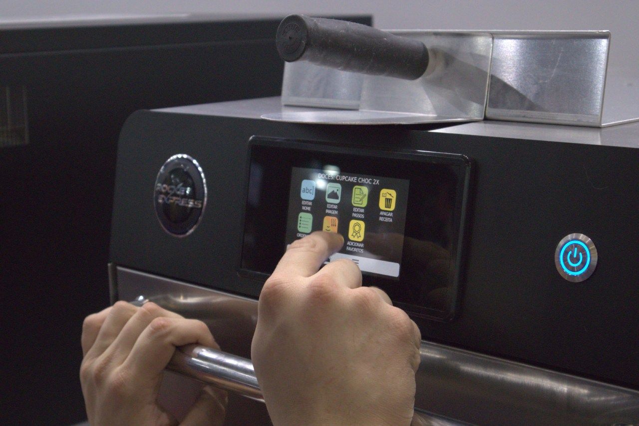 Uma pessoa está usando uma tela sensível ao toque para controlar uma máquina.