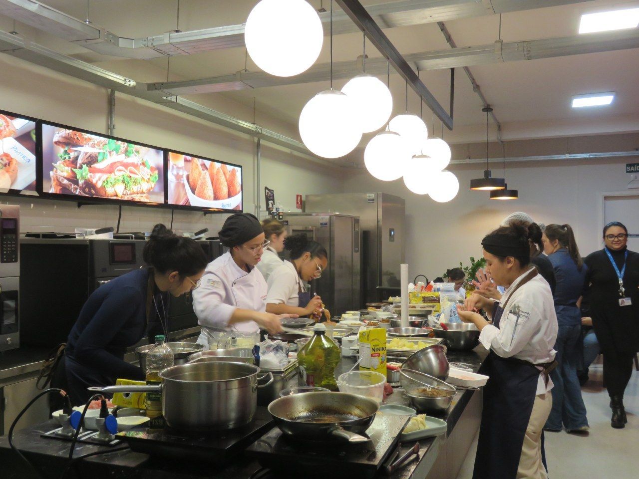 Um grupo de pessoas está preparando comida em uma cozinha